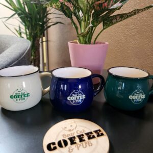 A set of cups and a holder with the word coffee kept on a wooden table.